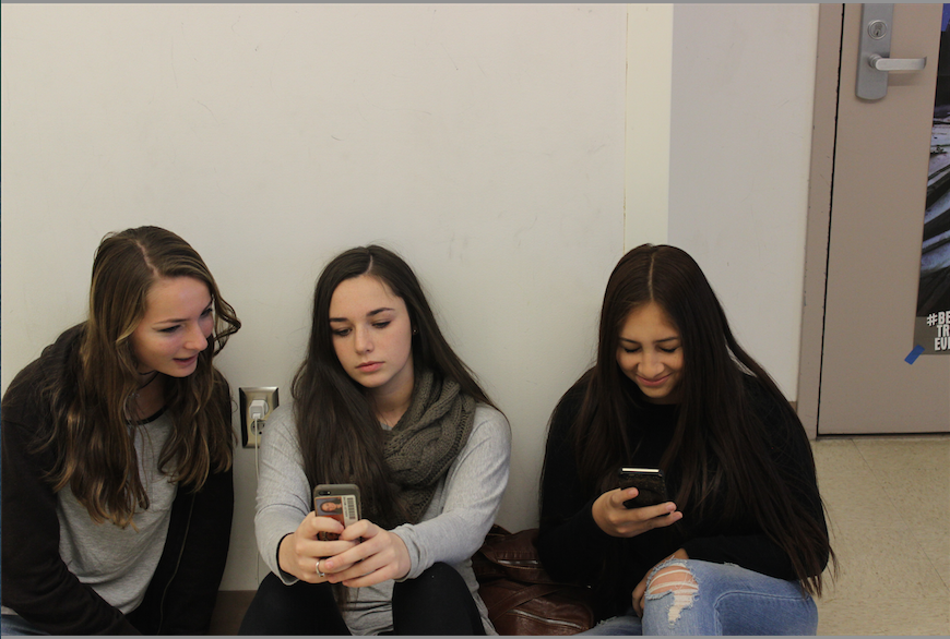 From left to right, freshmen Miriam Maemer, Ashley Michie and Inaya Zaman check out their phones during a break.