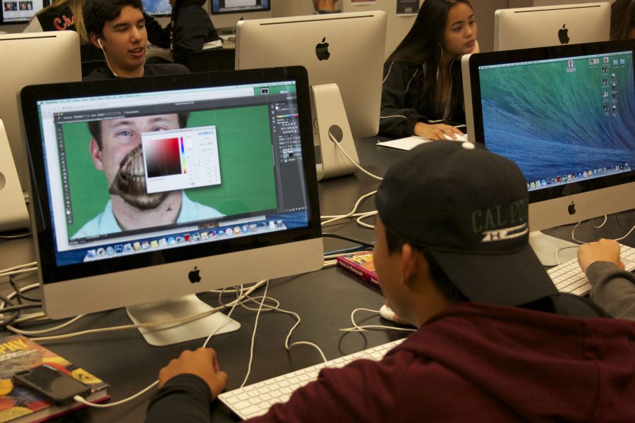 Junior Brandon Ignacio zombifying para educator Alex Kravitz on Photoshop in the spirit of tHalloween, as part of a digital photo project last month.