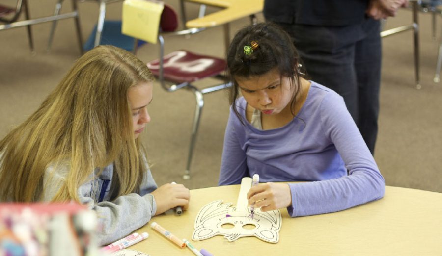 Leadership student Caitlin Willard, left, works with sophomore Erika Reed.  Students in the program work on several different arts and crafts projects on every visit. 