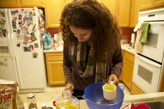 Junior Gabby Reid measures out the ingredients to make a Sweet Potato Mango Spice Cake, a special Kwanzaa recipe. 