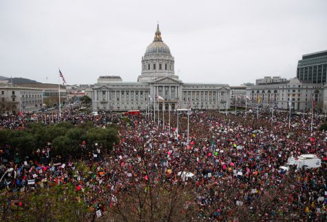 Above, thousands of people gathered for the Women’s March at Civic Center in San Francisco on Jan. 21. People marched to stand in solidarity with women, walking in large crowds well into the evening. Below, many people held signs promoting peace and equality at the San Francisco march on Market Street. Some of the signs had sayings that read, “No hate” and “We deserve equal rights.”