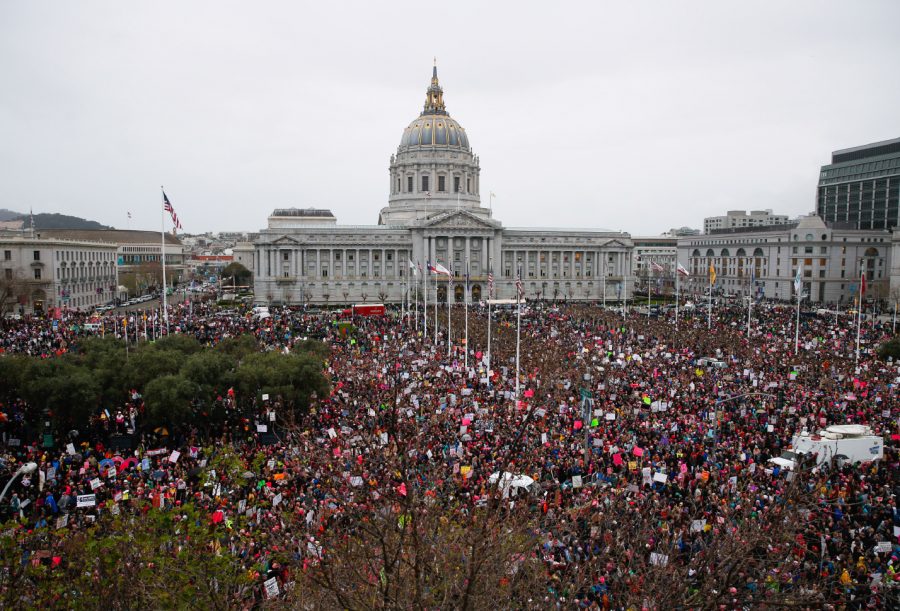 Above, thousands of people gathered for the Women’s March at Civic Center in San Francisco on Jan. 21. People marched to stand in solidarity with women, walking in large crowds well into the evening. Below, many people held signs promoting peace and equality at the San Francisco march on Market Street. Some of the signs had sayings that read, “No hate” and “We deserve equal rights.”