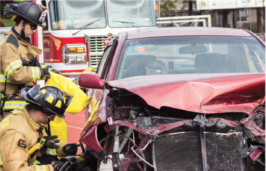 San Ramon Valley fire fighters work hard to rip open the car door and save an injured victim from the mock crash at Cal.