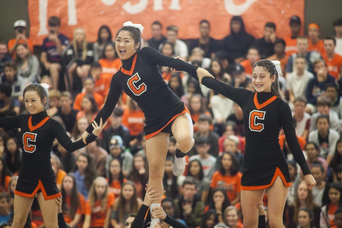 From left to right, sideline cheerleaders Samantha Fredrickson,  Isabelle Yoo, and Taylor Craig perform at the first rally. 