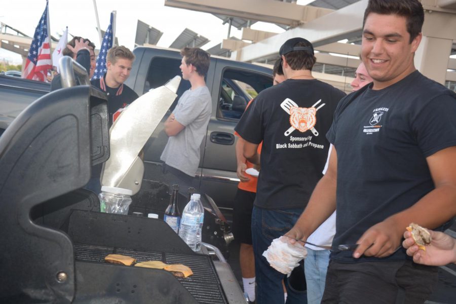 Senior Jack Jones grills up a few burgers at the tailgate in the back parking lot before a home football game last month.