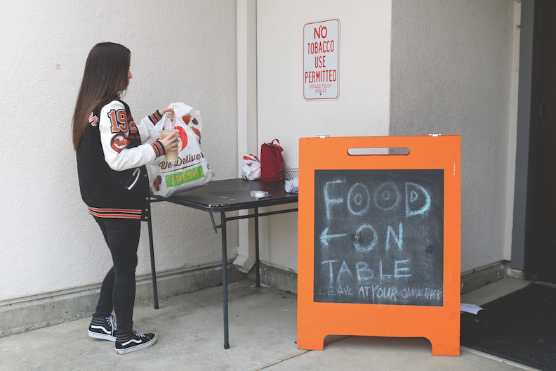 A student picks up her lunch at the food table located outside the front office, where many lunch thefts have occurred.