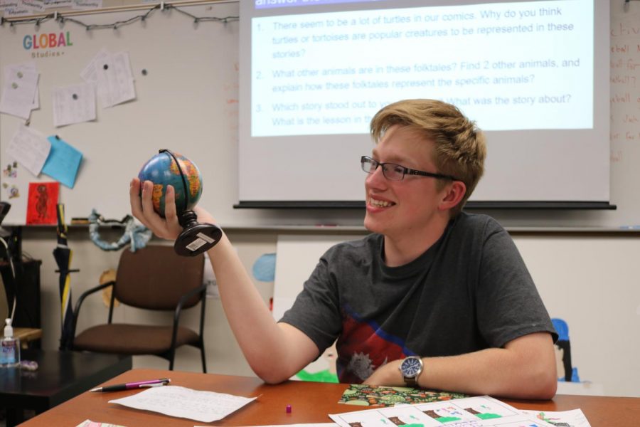 Harvey studies a world globe in geography teacher Hannah Cheng’s classroom.    