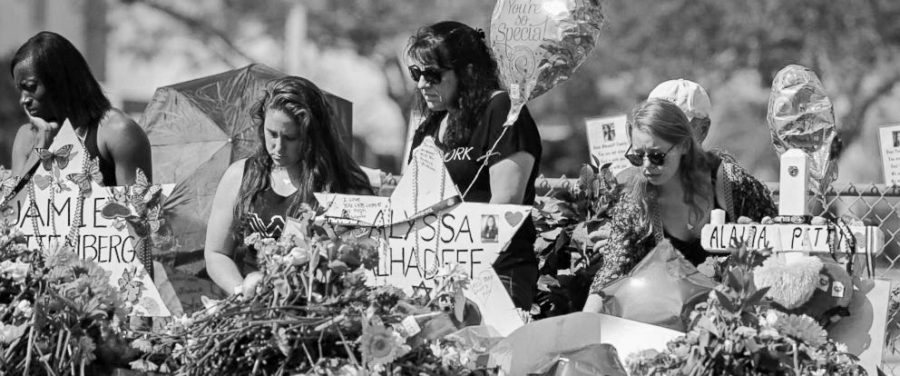 Mourners pay tribute at a memorial for victims at the Marjory Stoneman Douglas High School shooting. Two survivors, Sydney Aiello and Calvin Desir, recently committed suicide.