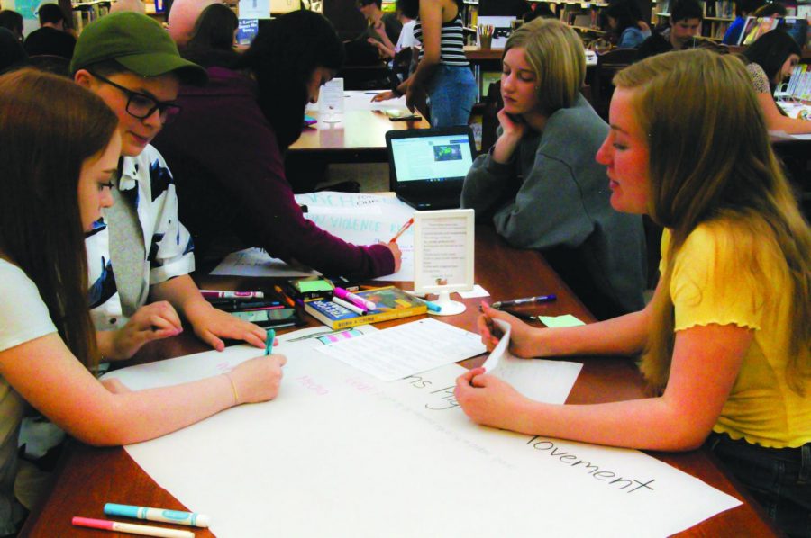 From left to right, sophomores Emily Meyer, Sam Gilstrap, Katrina Town, and Carina Plechaty design posters to share with incarcerated juveniles as part of teachers Hannah Cheng and Regina Lyons global studies class.