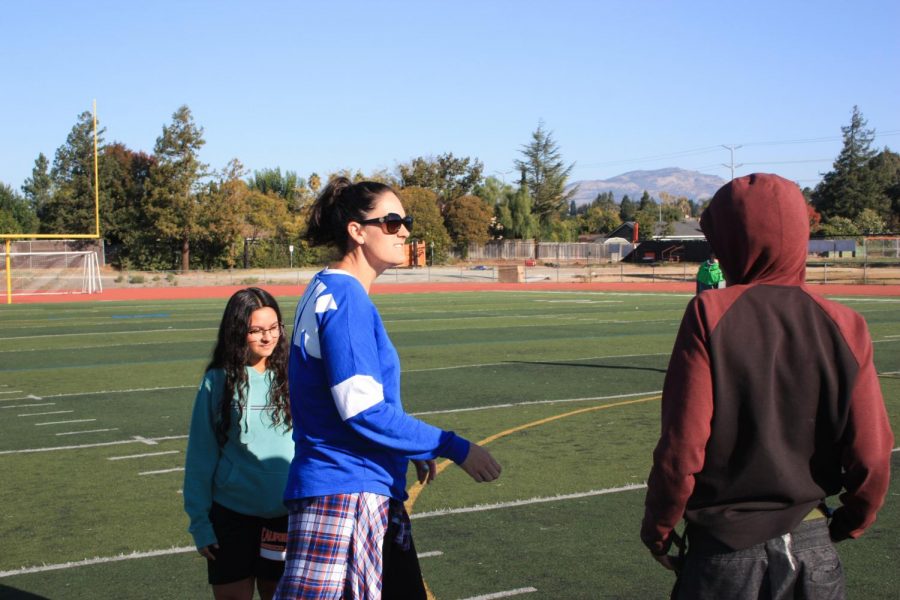 PE teacher Sheridan Kautzmann, left, talks to one of her students during class on the football field. 