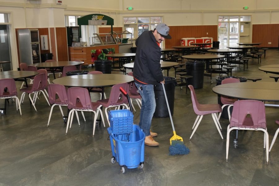 Custodian Ricky Galvao mops the commons floors after lunch. Hes one of 13 custodians who work at Cal High.