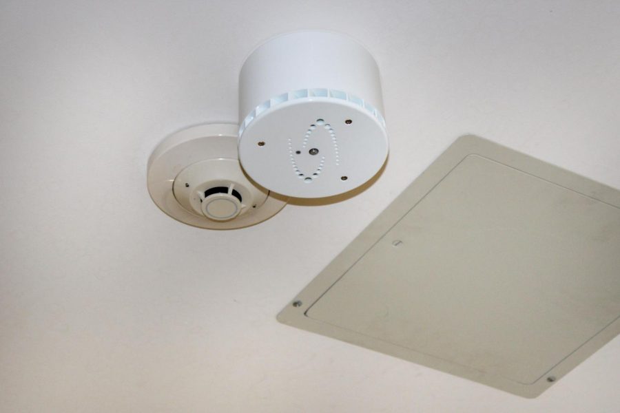 A new vape detector, pictured just to the right of a smoke detector, was just installed in the first floor gender neutral bathroom last month to discourage students from vaping.