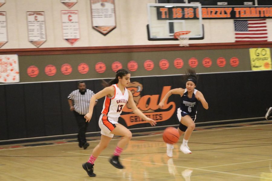 Junior Awva Bashiri (13) dribbles the ball upcourt against Dougherty Valley. Cal won the game 78-42 to improve to 15-8.