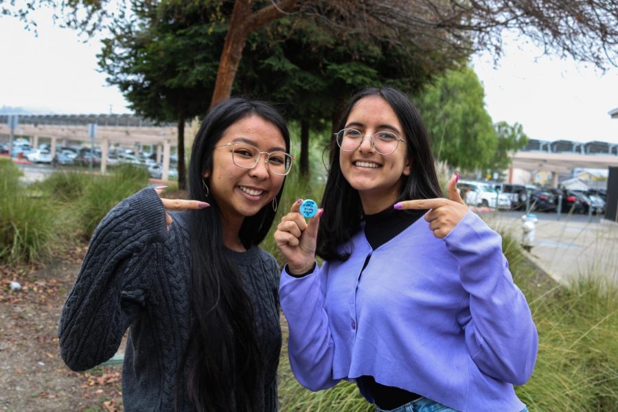 Pin Pals co-presidents and seniors Clarissa Mendoza, left, and Riya Belani pose with one of the pins that their club has designed for Saugus High School in Santa Clarita. Proceeds from pin sales went to support the Southern California school which experienced a shooting on Nov. 14 that killed two students.