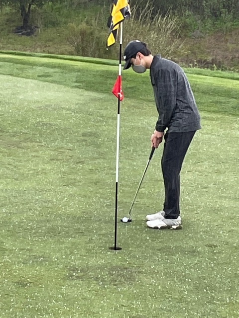 Golfer Jacob Rhodes is pictured putting on the sixth green at a golf tournament during a hail storm.