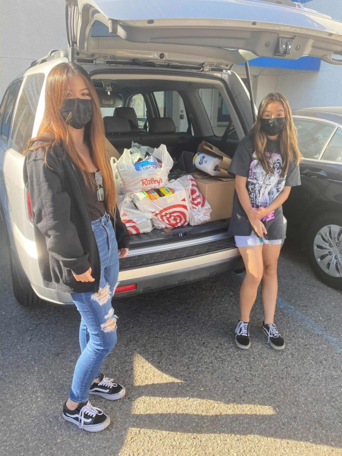 Seniors Audrey Zhang, left, and Kaitlyn Perry helped collect food and other supplies for an Interact service project that benefitted the Bay Area Rescue Mission.