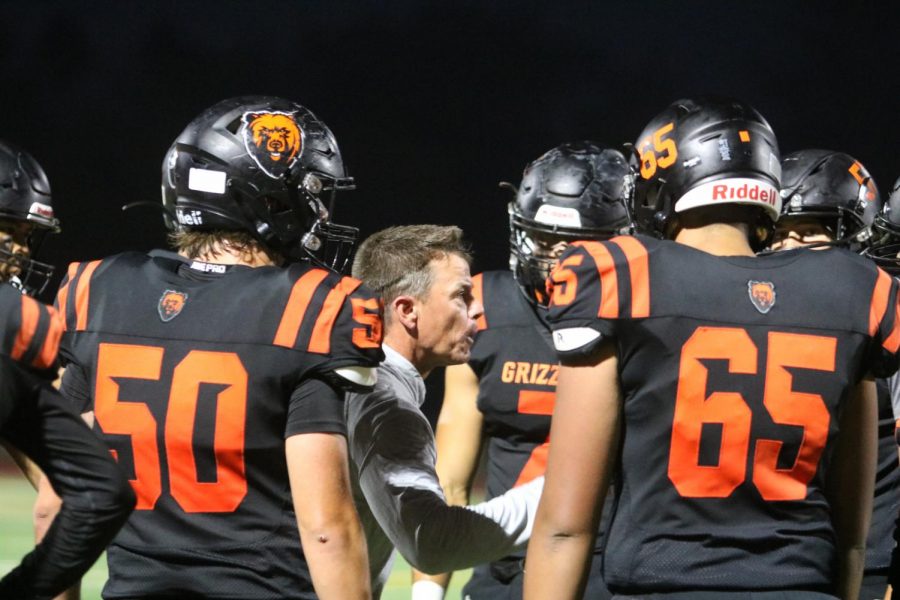 Varsity football coach Danny Calcagno talks with members of his team during Fridays homecoming game, which Cal won 41-7 over MIlpitas. All coaches and athletes are now required by the district to show proof of vaccination or be tested twice a week for COVID-19.