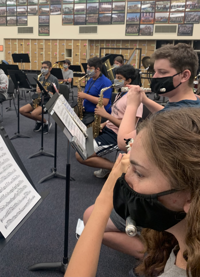 Members of the wind ensemble class play Sleigh Ride with their special masks, which include a slit for the instrument.