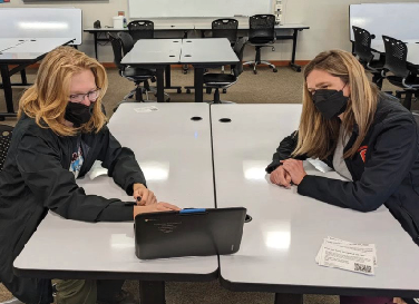 Senior Nicholas Harvey, left, and librarian Jessica Bailey review student budgeting votes.