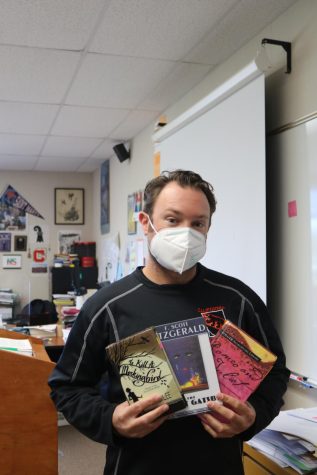 English teacher Nick Shea holds several books that his freshmen and junior classes read.