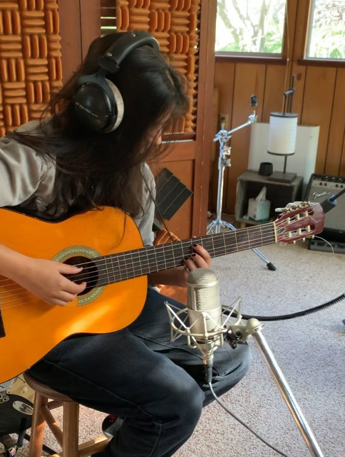 Junior Anushna Sapatnekar plays the guitar in the recording studio for their first ever album.