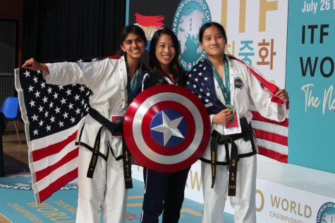 Flora Dixit, left, and Zora Choi, far right,  pose at Taekwon-Do World Championships this summer. The girls helped the USA Junior Girls Team four medals at the international competition, including a gold medal in specialty techniques. Choi earned six individual medals, while Dixit earned five medals.