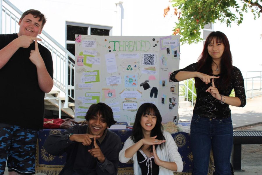 From left to right, Threaded’s officers Sam Saunders, Abhiraj Sharma, Lauren Lee, and Melissa Nguyen showcase their poster at club fair advocating sustainable, ecofriendly attire.
