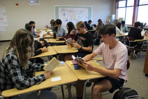 Sophomore Aidan Dube reads the book “Born a Crime” by Trevor Noah with other students in his English class.