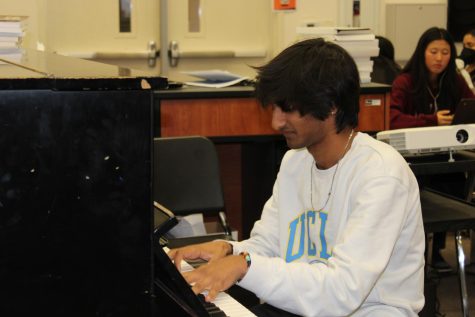 Gautam Vedula plays around on the piano, experimenting with different chords to hear how it sounds.