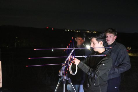 Senior Kian Kasad sets up an antenna to connect with the International Space Station at an Astronomy Club event.