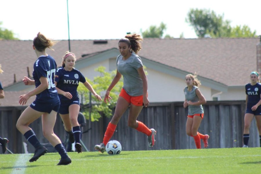 Zareena Mann tries to dribble past defenders while playing for the Pleasanton Rage club soccer team. She will be playing for Brandeis University in Massachusetts next year.