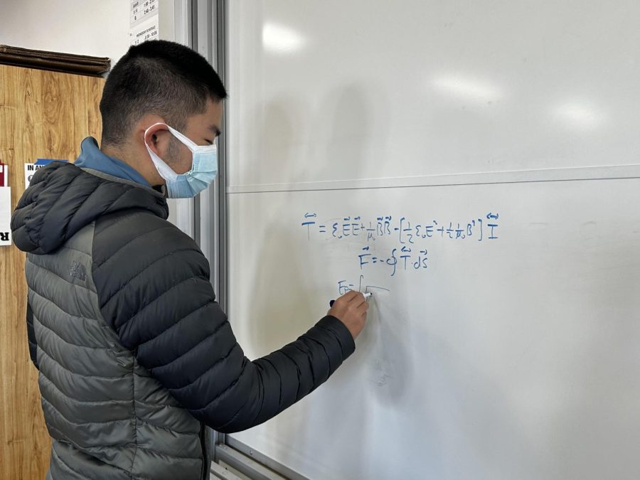 Senior Baiyu Zhu solves a problem on a board in the AP Environmental Science classroom. Zhu is part of the US National Physics Team and is president of Cal’s Physics Club.