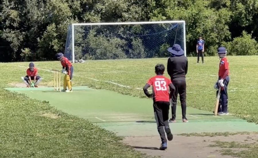 The young bowler prepares to bowl by running up the pitch while the batter prepares to hit the ball.  People of all ages can be found playing cricket in San Ramon and throughout the Bay Area as the sport becomes more popular in America.