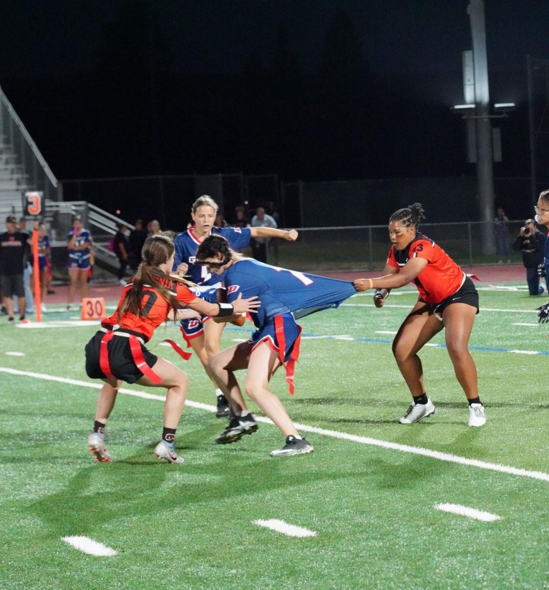 Sophomore Olivia Horton, far right, pulls a Dublin player by her jersey as teammate senior Lauren Grgurina, left, tries to pull the flag during the Grizzlies 24-0 victory on Sept. 12. Cal is 9-1 overall and 7-0 in EBAL play so far this season.