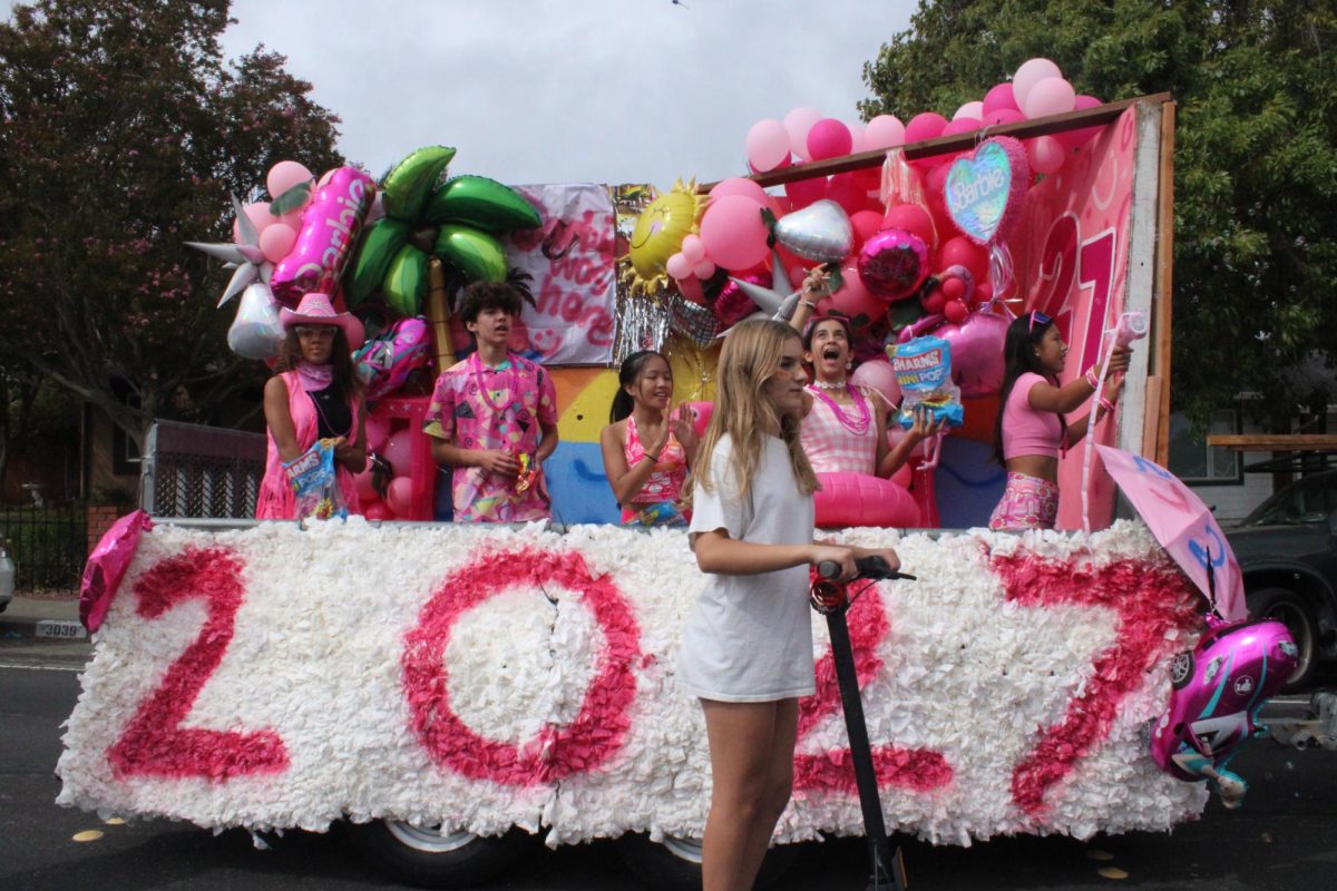 Freshmen cheer from the Class of 2027 float. Volunteers covered graffiti on the float so it could run in the parade.