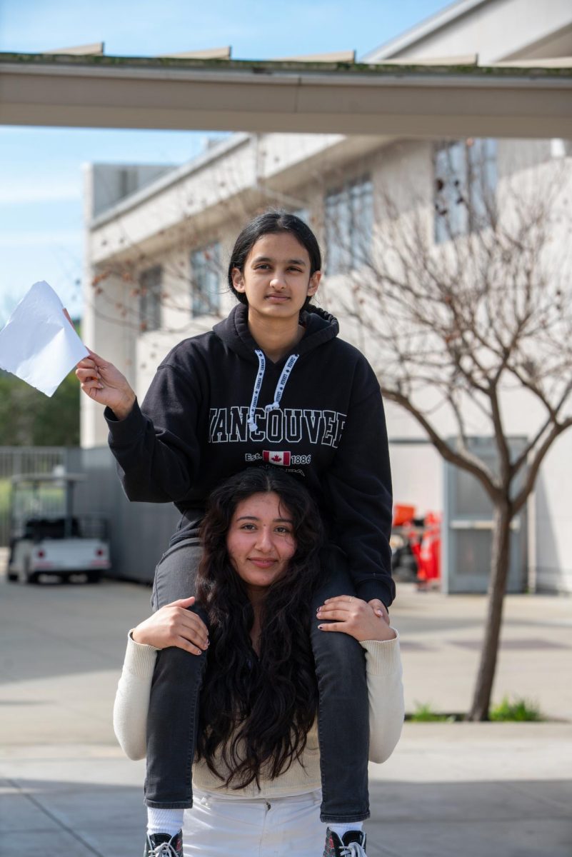 Senior Shivani Phadnis sits atop her partner senior Sarah Flores’ shoulders while waving her flag in defeat.