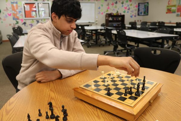 Chess club president Zarian Iqbal often plays alone since no one attends his club meeting.