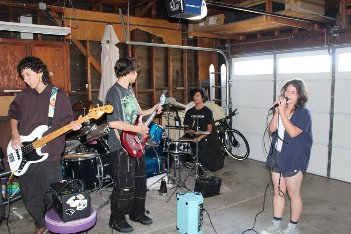Members of the band Friendly Fire get ready for their next gig by rehearsing in drummer Lucas Chan’s garage. Other band members include bassist Orion Duerrmeier, left, guitarist Mojo Maldonado, center, and singer Viktoria Lutsenko.