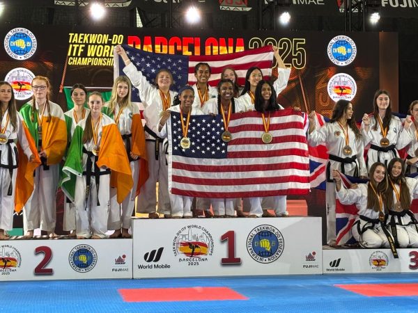 Cal High freshman Laksha Iyer, bottom right standing on first place podium, and her team celebrates their gold medal in powerbreaking at the ITF Taekwondo World Champship 2025 in Barcelona. The team also won a pair of silver medals.