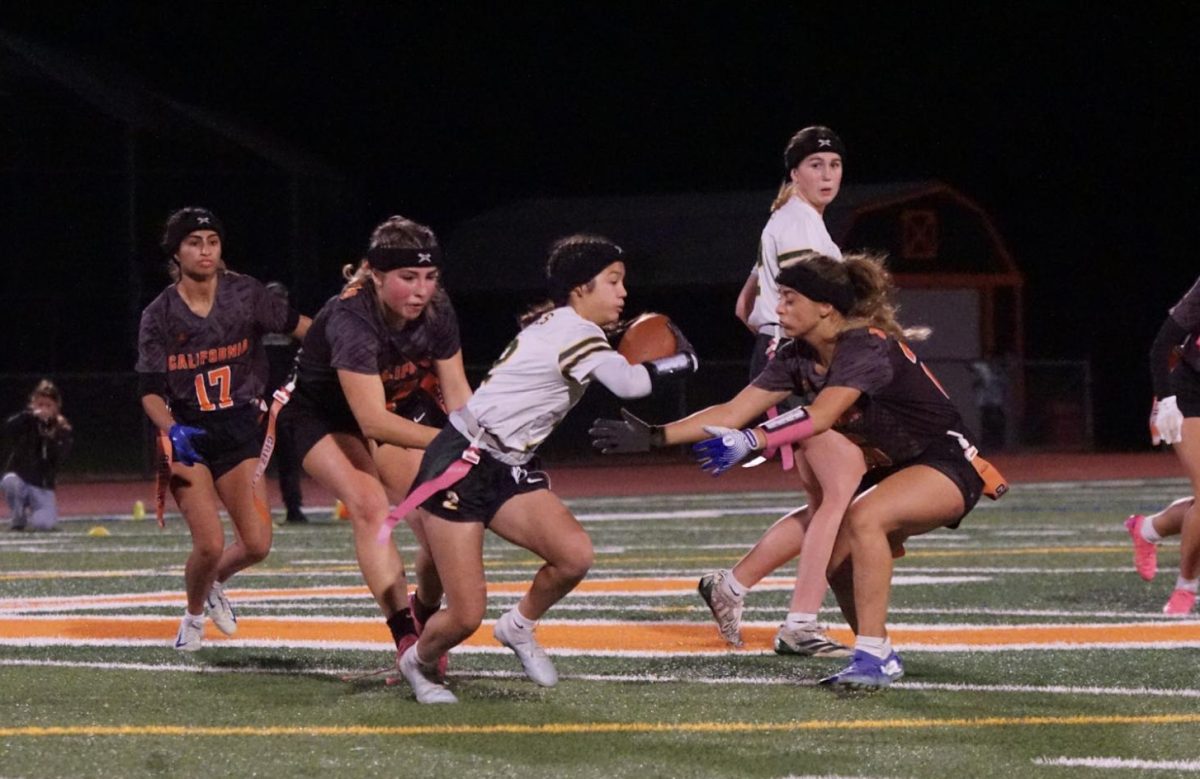 Senior Janie Trottier grabs the flag of a San Ramon Valley player during the NCS Division 1 semifinals, while junior Mia Donati, right, tries to block her path. Cal lost the game 13-24.