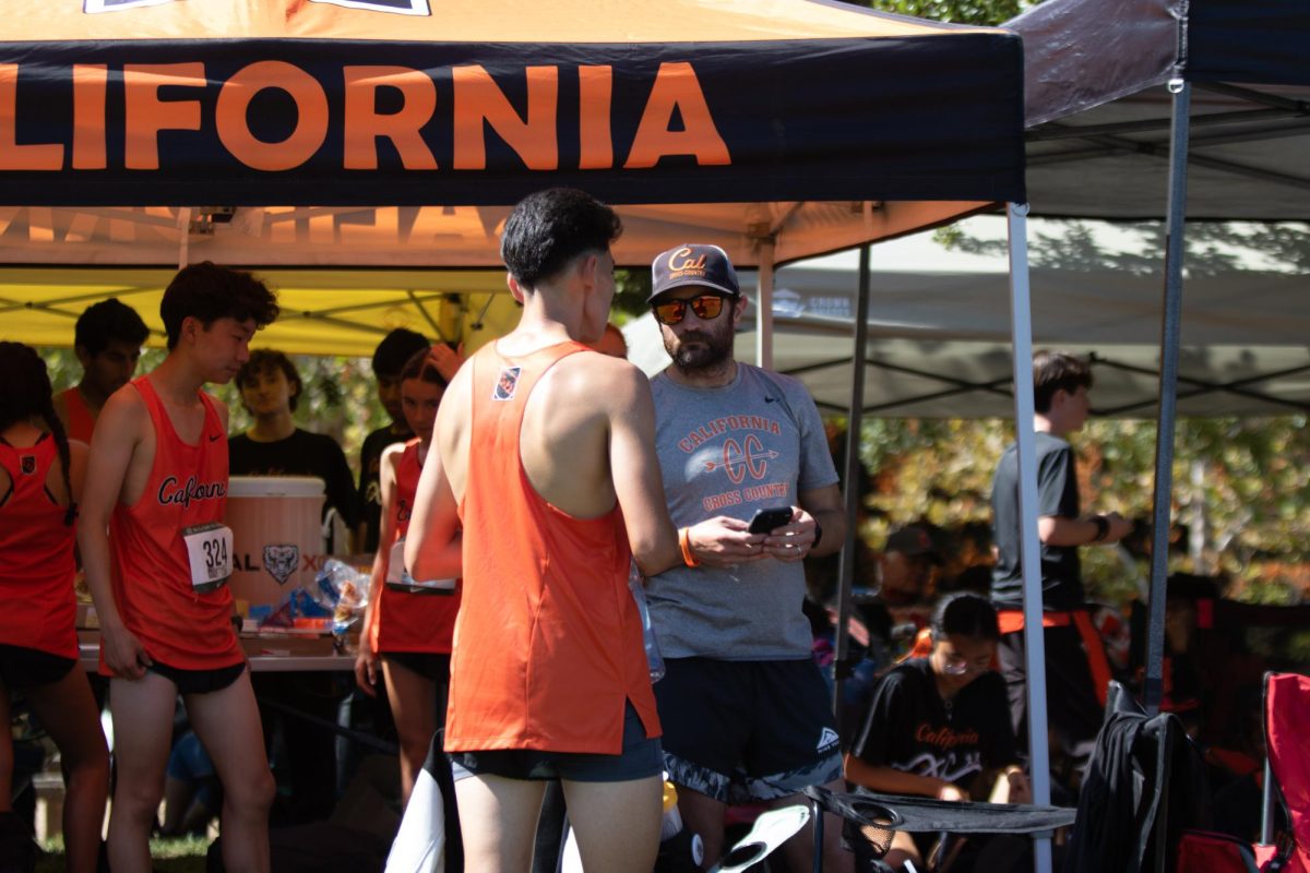 Coach Nicholas Shea, right, talks with sophomore runner Benjamin Moran during a Cal meet. Shea has been coaching at Cal for 10 years. 