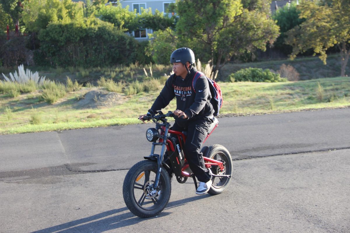 Sophomore Aiden Cortez rides his ebike along the Iron Horse Trail on his way to school.
