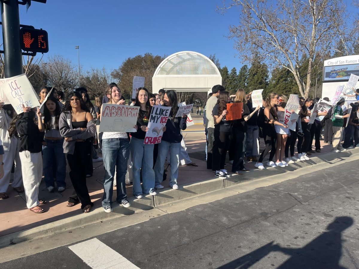 Students at Cal High take part in the walkout against ICE while holding posters.
