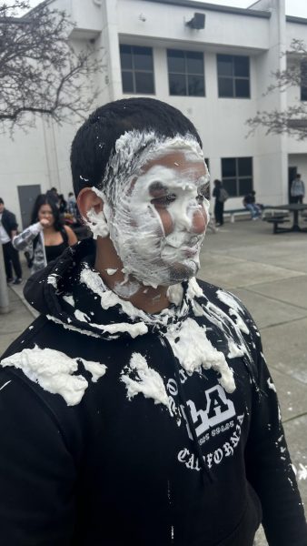 Senior Aryan Patil wallows in his shame after being pied, left, and drenched in milk. After being rejected by a different girl each day leading up to Senior Ball, Patil faced increasingly flamboyant punishments that he came up with.