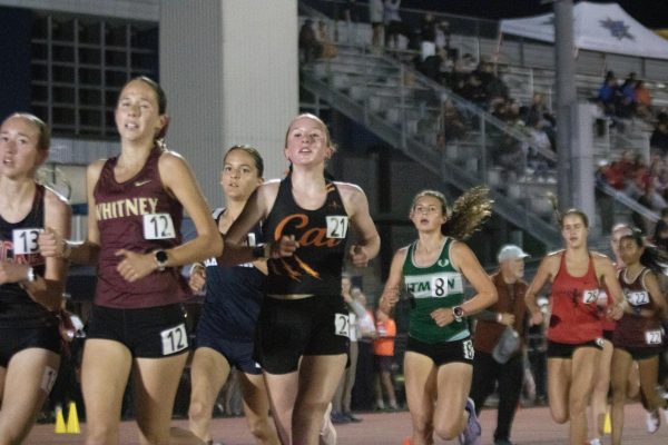 Left, junior Emily Bellinger (21) runs the 3,200 meters at Dublin Distance Fiesta, where she placed 13th out of 222 athletes. 