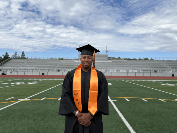 Principal Demetrius Ball stands with graduation atire after four years of being at Cal High.