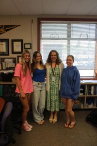 From left to right, seniors Madelyn Feick, Lily Hann, AP Psychology and iQuest teacher Sarah Eddings and Paige Thorgrimsson pose in class before the students graduate in June.