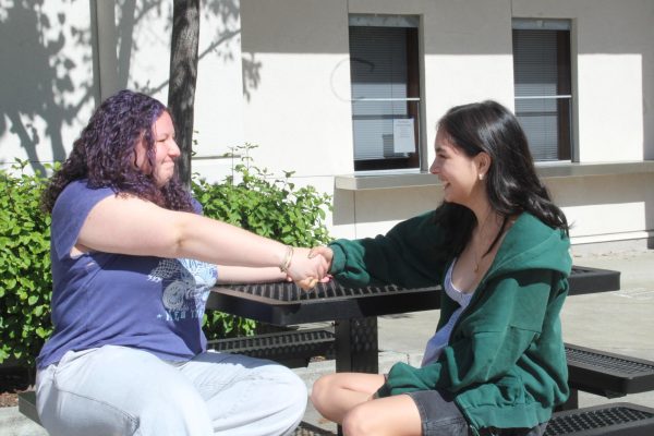 Senior Daniela Noubleau shares a table with her friend, senior Michelle Kennedy, while looking back at their freshmen year when both of them were new to Cal High.